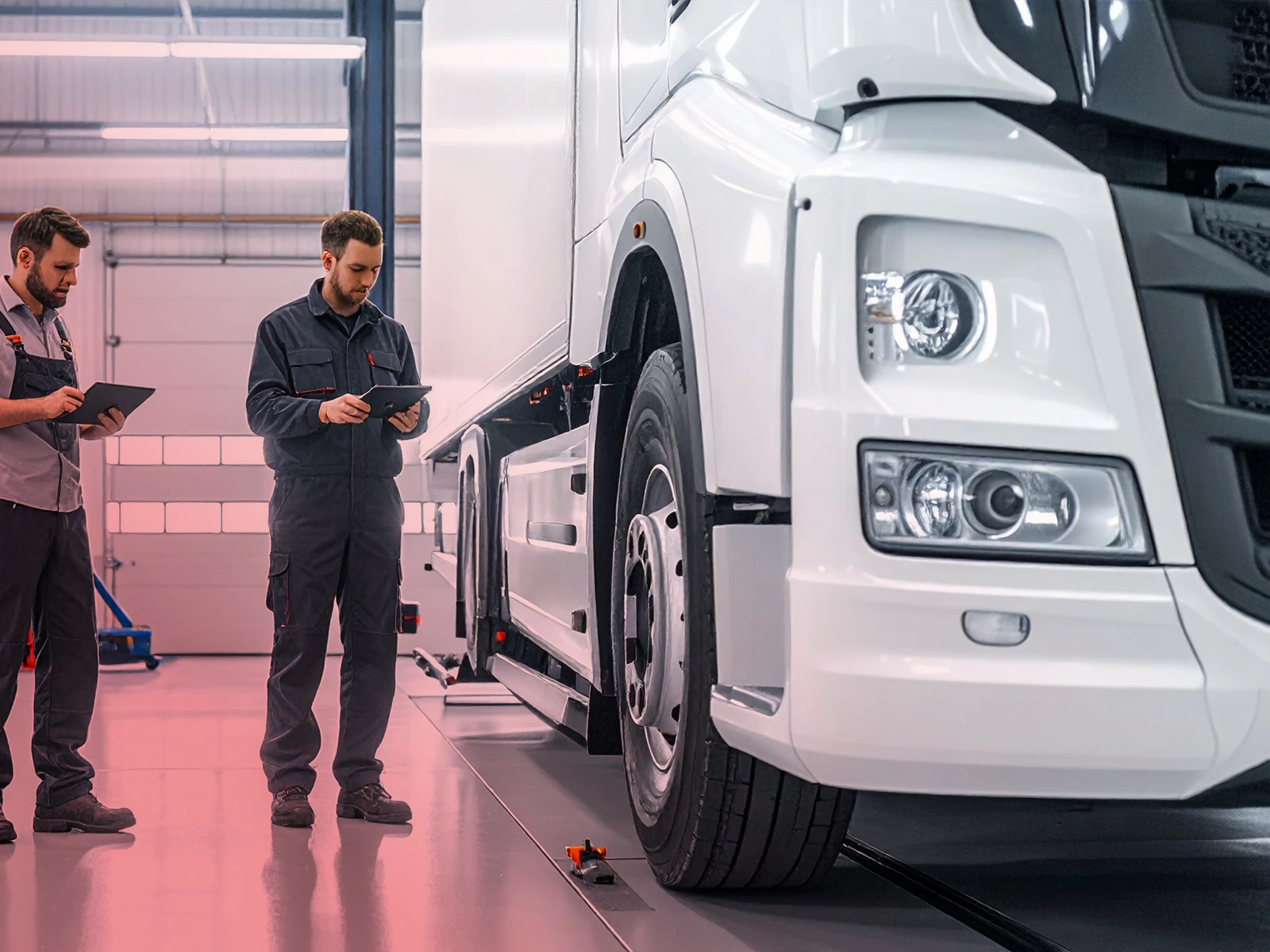 LKW-Service - Weißer 7,2 T LKW wird von 2 Mitarbeitern geprüft.