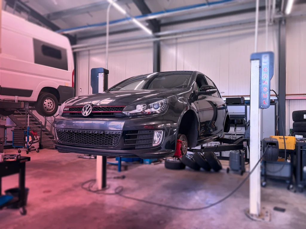 Personenkraftwagen Service: Alle Leistungen aus einer Hand 4 PKW-Service - Fahrzeug ohne Räder auf der Hebebühne hochgefahren.